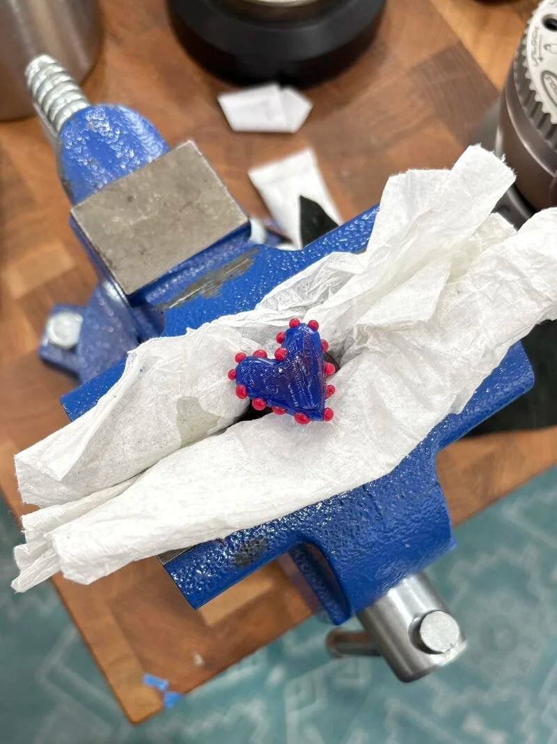 Blue wax casting mold held in a bench vise