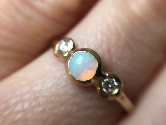 Gold ring with an opal stone on a finger