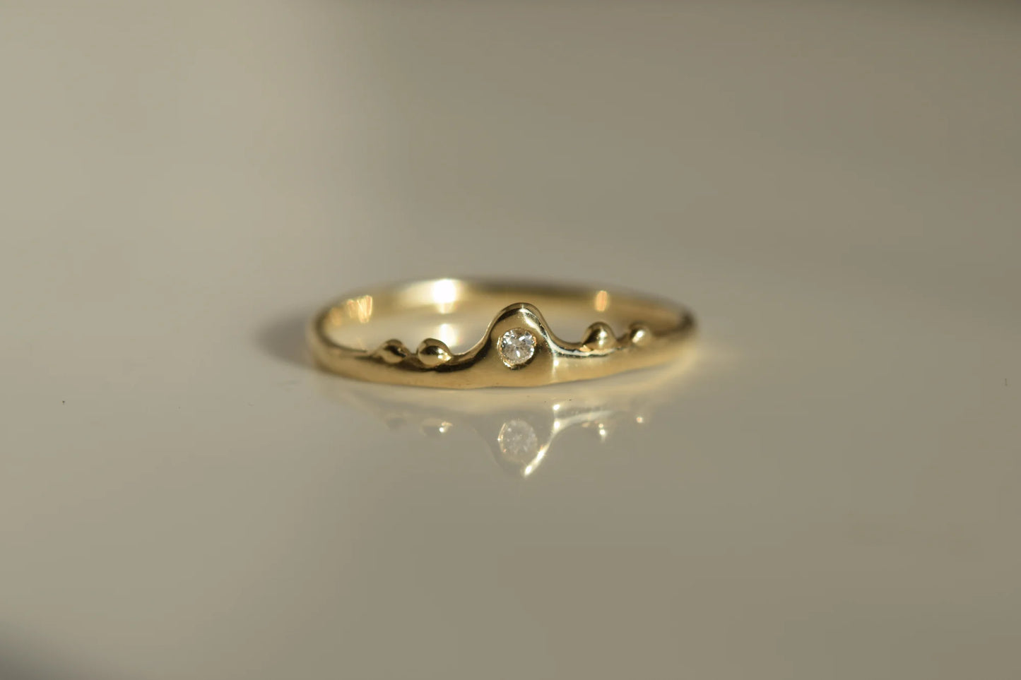 Gold ring with a small diamond on a gray background