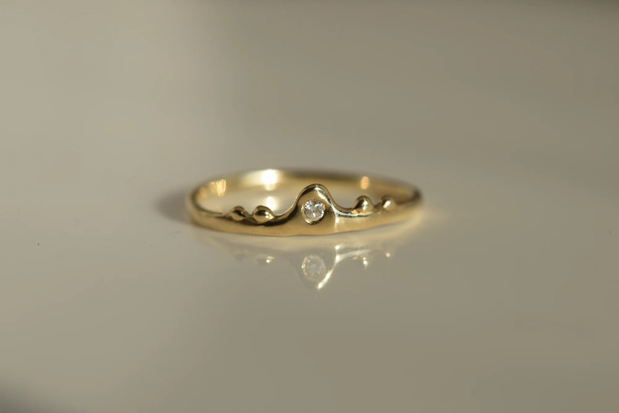Gold ring with a small diamond on a gray background